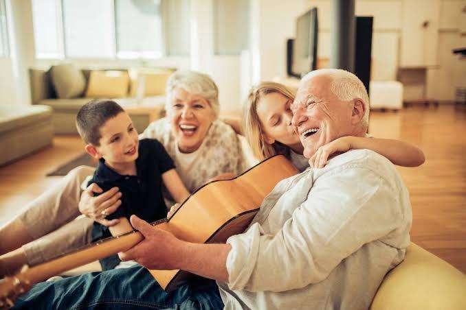 Família reunida com avô tocando violão